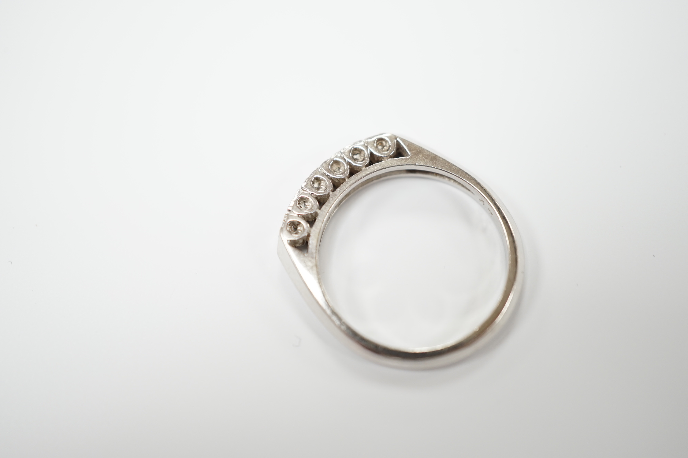 A 14k white metal and six stone diamond chip set half hoop ring, size L, gross weight 2.6 grams.